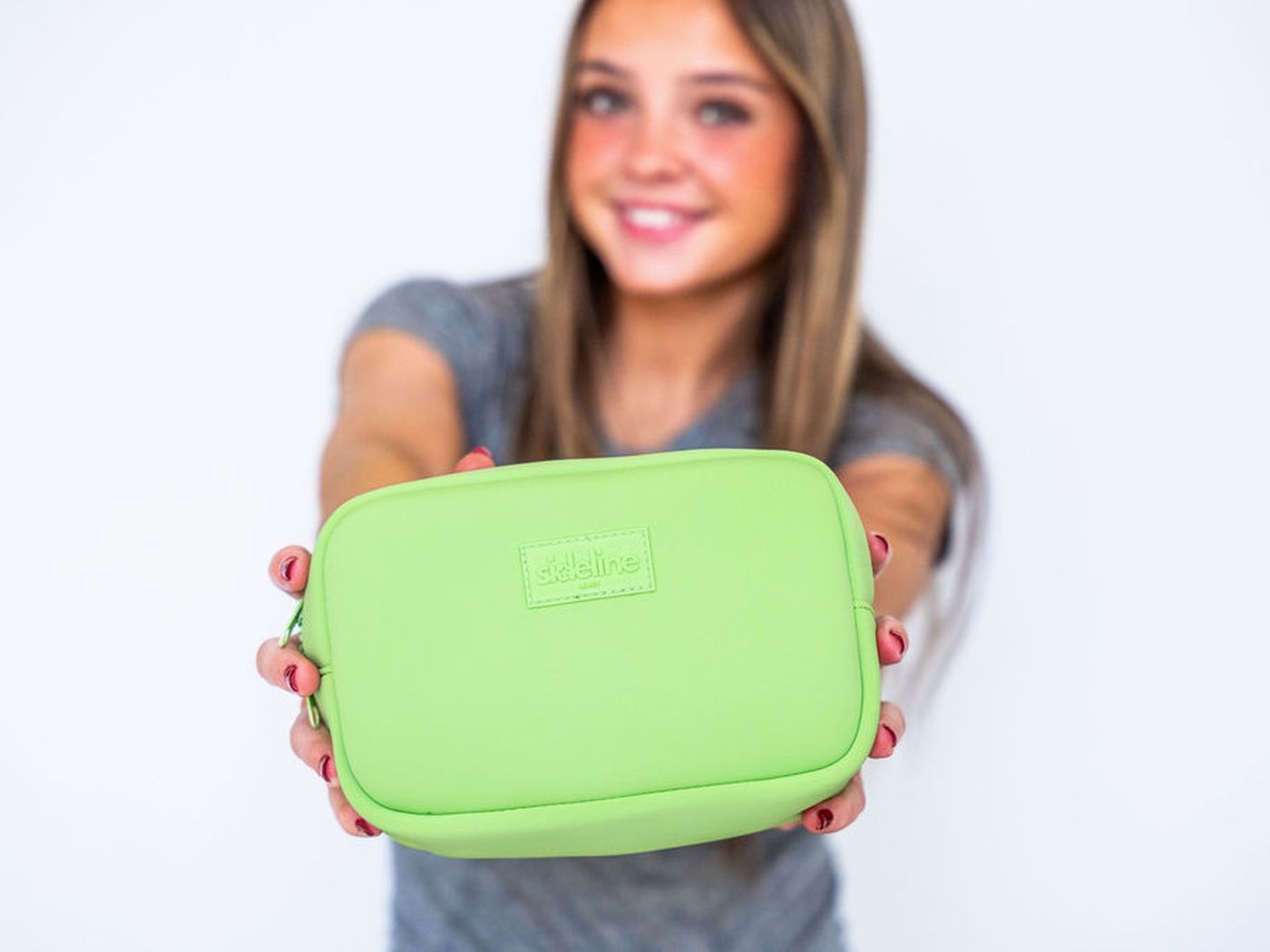 Holding a lime green SLB out to the camera, grinning